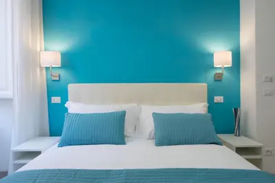 a blue bedroom with a white bed with two blue pillows at Le Stanze Di Gaia in Rome