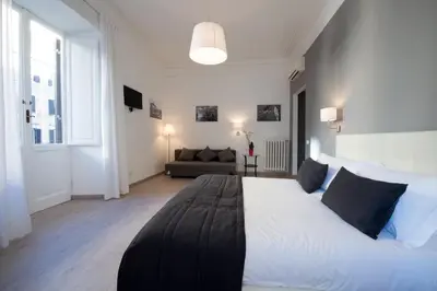 a bedroom with a large white bed and a couch at Le Stanze Di Gaia in Rome