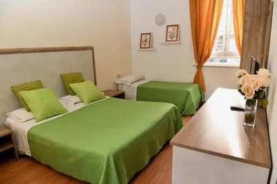 a hotel room with two beds with green sheets at Hotel Anacapri in Rome