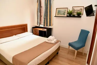 a bedroom with a bed and a blue chair at Hotel Anacapri in Rome