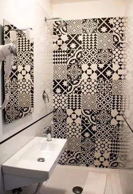 a bathroom with a sink and a black and white tile wall at Hotel Anacapri in Rome