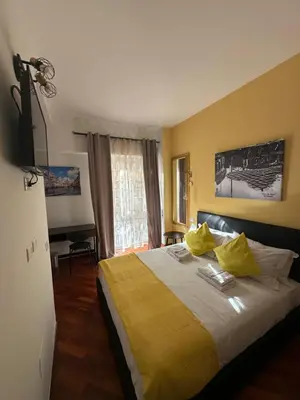 a bedroom with a bed with yellow sheets and yellow pillows at Vatican QG Rooms in Rome