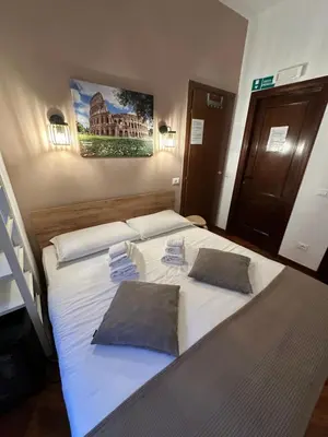a bedroom with a large white bed with two pillows at Vatican QG Rooms in Rome