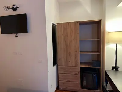 a room with a closet with a tv on a wall at Vatican QG Rooms in Rome