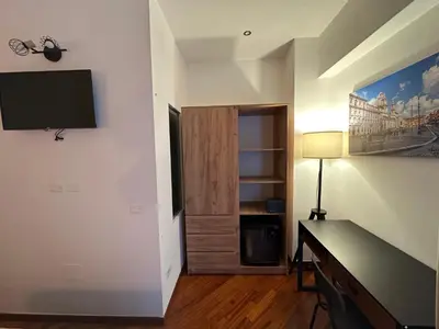 a room with a desk and a television on a wall at Vatican QG Rooms in Rome