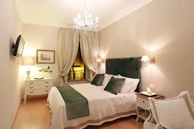 a bedroom with a large bed and a chandelier at Daplace - Ottavia Apartment in Rome