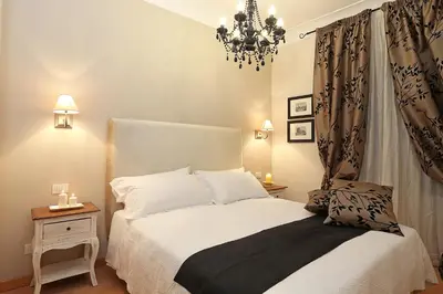 a bedroom with a white bed and a chandelier at Daplace - Ottavia Apartment in Rome