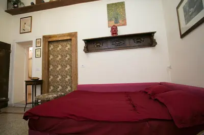 a bedroom with a bed with a red comforter at Vicolo Vecchio 59 in Rome
