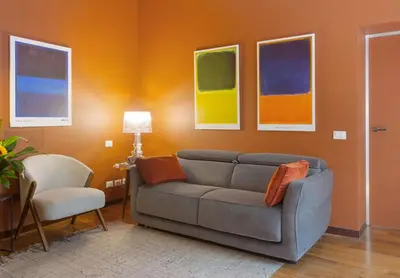 a living room with a couch and paintings on the wall at L'obelisque maison de luxe in Rome
