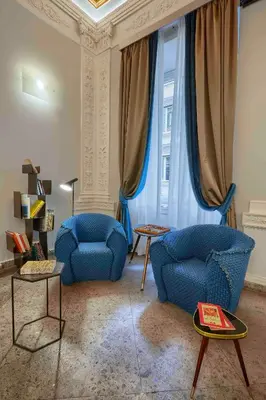 a living room with two blue chairs and a window at L'obelisque maison de luxe in Rome
