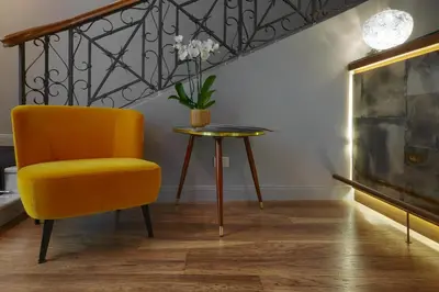 a yellow chair and a table in a room at L'obelisque maison de luxe in Rome