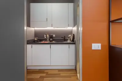 a kitchen with white cabinets and a sink at L'obelisque maison de luxe in Rome