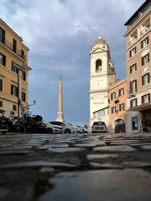 a building with a tower in the middle of a street at L'obelisque maison de luxe in Rome