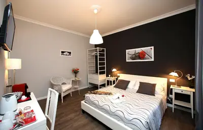 a bedroom with a white bed and a black wall at A 2 Passi Dai Musei Luxury Guest House in Rome