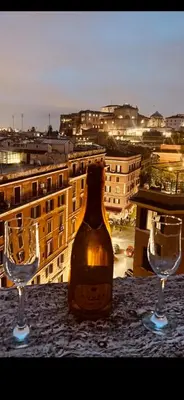 a bottle of wine sitting between two glasses on a table at A 2 Passi Dai Musei Luxury Guest House in Rome