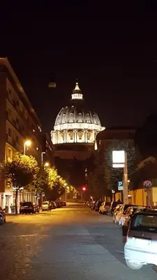 a lit up building on a city street at night at S Peter Nicolo' III in Rome