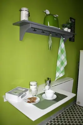 a kitchen with a green wall with a shelf at S Peter Nicolo' III in Rome