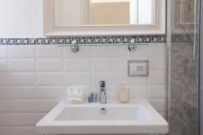 a white sink in a bathroom with a mirror at InnsideRome in Rome