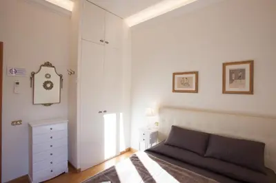 a bedroom with a bed and a dresser and a clock at InnsideRome in Rome