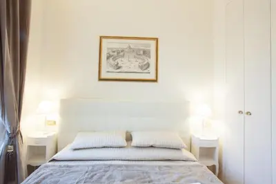 a white bedroom with a bed and two night stands at InnsideRome in Rome