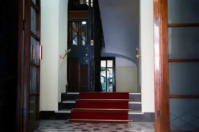 a hallway with red carpeted stairs and a blue door at Suite Cardinale in Rome