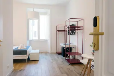 a bedroom with a bed and a room with a table at Suite Cardinale in Rome