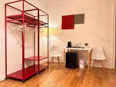 a red shelf in a room with a table at Suite Cardinale in Rome