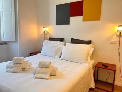 a bedroom with a large white bed with towels on it at Suite Cardinale in Rome