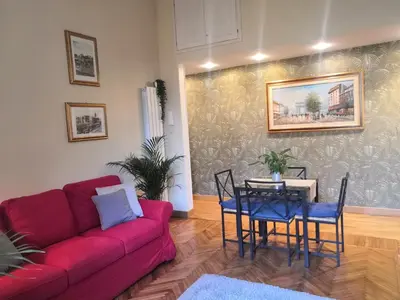 a living room with a red couch and a table at Tevere Rome Apartments in Rome