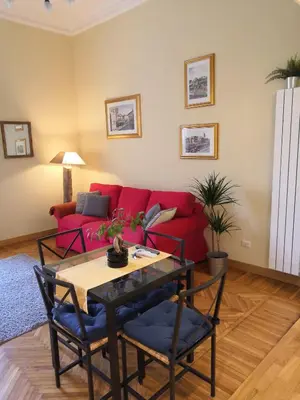 a living room with a red couch and a table at Tevere Rome Apartments in Rome