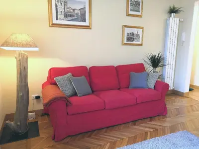 a red couch in a living room with a lamp at Tevere Rome Apartments in Rome