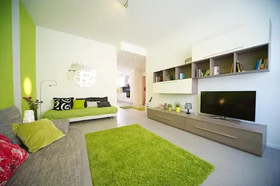 a living room with a green couch and a television at Lungotevere Holidays in Rome