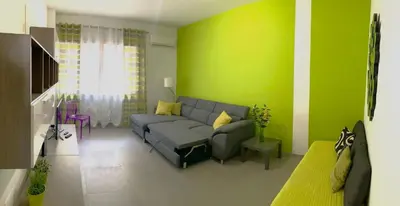 a living room with a couch and a green wall at Lungotevere Holidays in Rome