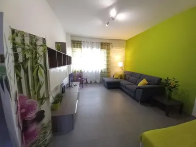 a living room with a couch and a green wall at Lungotevere Holidays in Rome