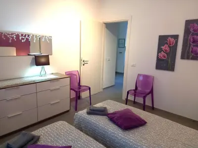 a bedroom with two beds and two purple chairs at Lungotevere Holidays in Rome