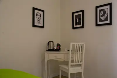 a room with a desk with a chair and pictures on the wall at Mikasa Piazza Bologna in Rome