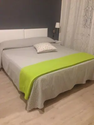 a bed with a green blanket on top of it at Mikasa Piazza Bologna in Rome