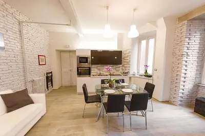 a dining room and living room with a table and chairs at Modern Apartment near Colosseum in Rome