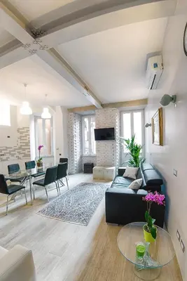 a living room with a black couch and a table at Modern Apartment near Colosseum in Rome