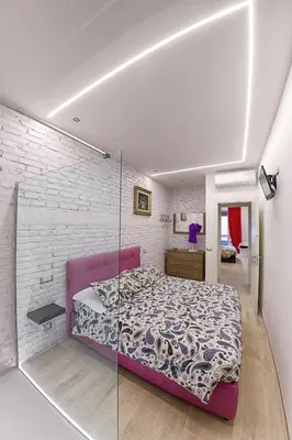 a bedroom with a bed and a glass wall at Modern Apartment near Colosseum in Rome
