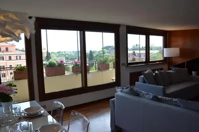 a living room with couches and a table and windows at Penthouse Cardello Colosseum in Rome