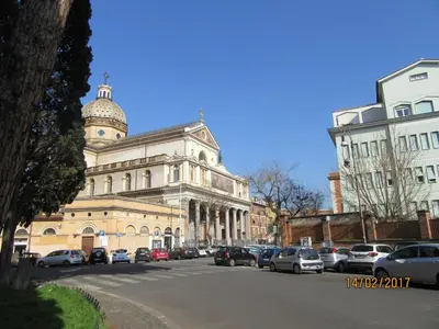 a large building with cars parked in a parking lot at Alloggio Quiriti in Rome