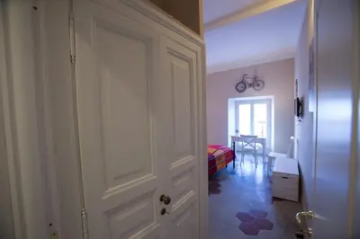 a hallway with a door and a room with a table at Alloggio Quiriti in Rome
