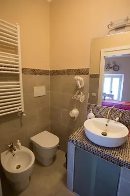 a bathroom with a sink and a toilet and a mirror at Alloggio Quiriti in Rome