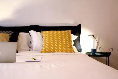 a bedroom with a bed with a yellow pillow at La Controra Guesthouse Roma in Rome