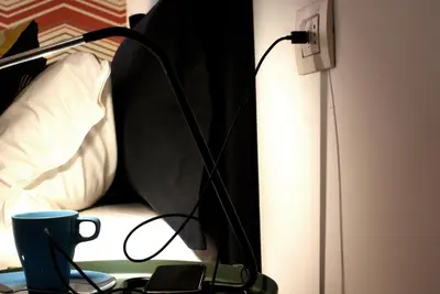 a lamp on a table next to a bed at La Controra Guesthouse Roma in Rome