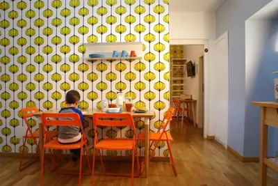 a young boy sitting at a table in a kitchen at La Controra Guesthouse Roma in Rome