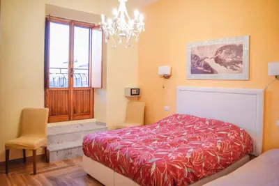 a bedroom with a red bed and a chandelier at Penthouse Angelo Brunetti in Rome