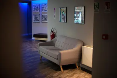 a living room with a white couch and a blue light at Hostel Trastevere in Rome