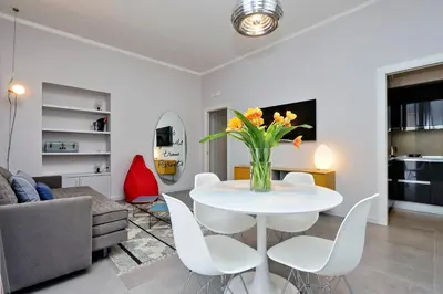a living room with a white table with a vase of flowers at Propaganda Suites in Rome